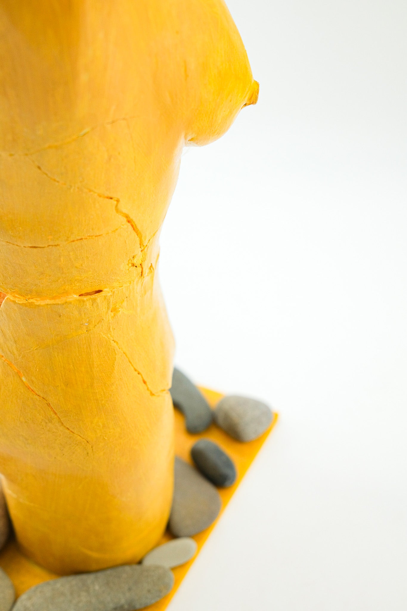 Yellow Female Torso Sculpture with Pebbles / 黄色い裸婦の像