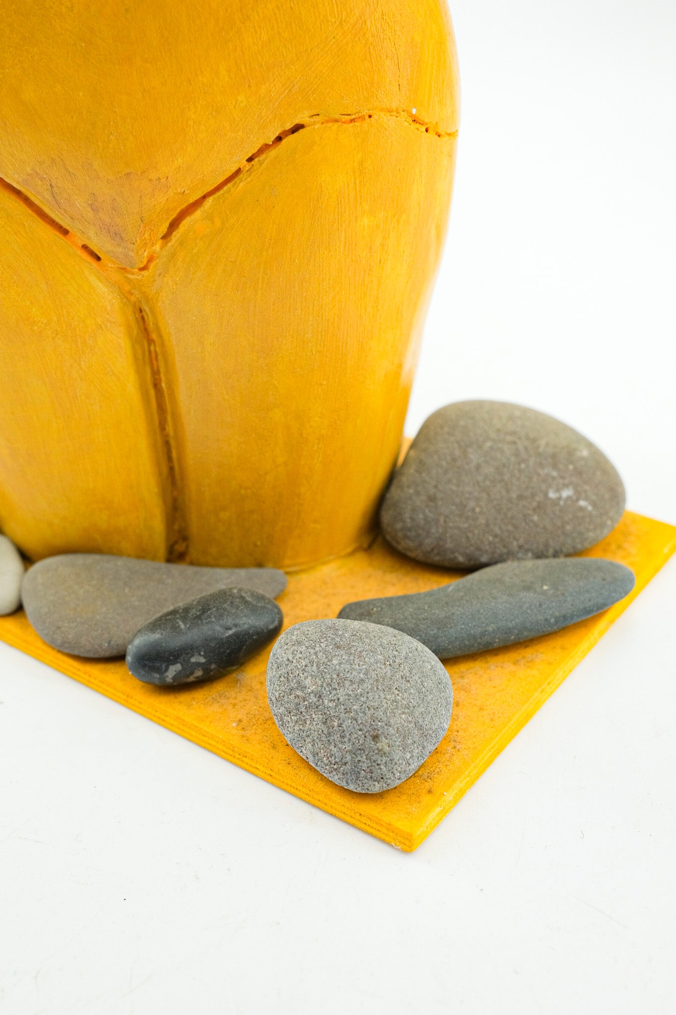 Yellow Female Torso Sculpture with Pebbles / 黄色い裸婦の像